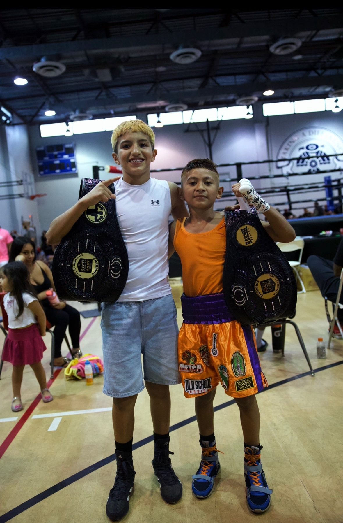 Two young Old School Boxing Club fighters holding championship belts