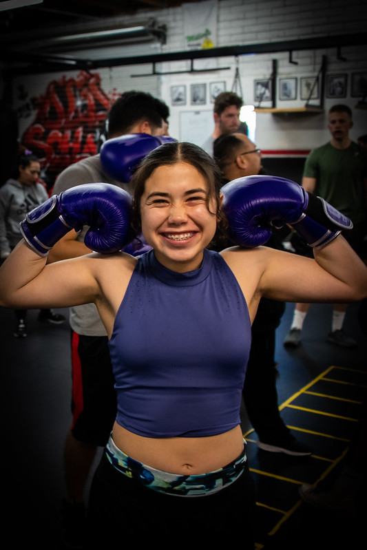 GCU Club Boxing athlete smiling in purple gloves